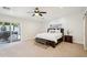 Spacious main bedroom featuring a ceiling fan, neutral carpeting, and sliding glass doors to a spa at 4920 E Osborn Rd, Phoenix, AZ 85018
