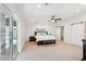 Bright bedroom featuring a ceiling fan, neutral carpeting, barn door access to a large walk-in closet, and ensuite bathroom at 4920 E Osborn Rd, Phoenix, AZ 85018