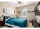 Carpeted bedroom with ceiling fan, bed with blue comforter, and decorative wall art at 5612 S 21St Pl, Phoenix, AZ 85040
