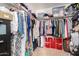 Walk-in closet contains shelving and hanging racks overflowing with a variety of clothing, shoes and accessories at 5612 S 21St Pl, Phoenix, AZ 85040
