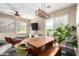 Bright dining room showcasing a long wooden table, an eclectic seating arrangement and verdant greenery near sunny windows at 5612 S 21St Pl, Phoenix, AZ 85040