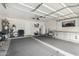Spacious two car garage with painted white walls and ceiling, shelving, and smooth flooring at 5612 S 21St Pl, Phoenix, AZ 85040