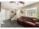 Cozy living room featuring a comfortable leather sofa, a staircase, and modern tile flooring at 5612 S 21St Pl, Phoenix, AZ 85040