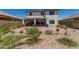 Landscaped backyard featuring a covered patio, gravel ground cover, and various flowering plants at 6305 W Pleasant Oak Ct, Florence, AZ 85132