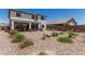 Expansive backyard showcasing desert landscaping with a covered patio and vibrant flowers at 6305 W Pleasant Oak Ct, Florence, AZ 85132