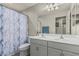 Bright bathroom featuring a double sink vanity, large mirror, decorative shower curtain and modern fixtures at 6305 W Pleasant Oak Ct, Florence, AZ 85132