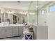 Bright bathroom featuring dual sinks, gray cabinets, decorative accents, and an oversized walk-in shower at 6305 W Pleasant Oak Ct, Florence, AZ 85132