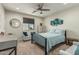Well-lit bedroom with a full-sized bed, window, artwork, and sitting area at 6305 W Pleasant Oak Ct, Florence, AZ 85132