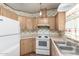 Kitchen features a white refrigerator and range with stainless steel sink and cabinets at 6391 S Oakmont Dr, Chandler, AZ 85249
