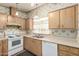 Cozy kitchen with a double sink, dated appliances, and wooden cabinets for ample storage at 6391 S Oakmont Dr, Chandler, AZ 85249