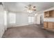 Open living room with carpet flooring, a ceiling fan, and natural light from the windows at 6391 S Oakmont Dr, Chandler, AZ 85249