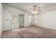 Spacious living room featuring neutral carpet, a ceiling fan, and sliding glass doors at 6391 S Oakmont Dr, Chandler, AZ 85249