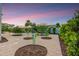 Serene backyard featuring gravel landscaping, lush trees, and an umbrella shaded seating area at 8500 W Nicolet Ave, Glendale, AZ 85305