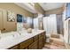 Functional bathroom with double sinks, a shower-tub combo, and decor at 8500 W Nicolet Ave, Glendale, AZ 85305