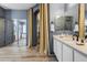A bright bathroom has gray walls, double sinks, and tan curtains leading to a separate room at 8500 W Nicolet Ave, Glendale, AZ 85305