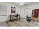 Bright bedroom showcasing wood floors, a desk, an art easel, and two windows with natural light at 8500 W Nicolet Ave, Glendale, AZ 85305