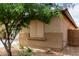 Home exterior showing a neutral color scheme, accented by a mature tree and tidy landscaping, and a block wall at 8848 W Cordes Rd, Tolleson, AZ 85353