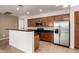 Well-appointed kitchen with stainless steel refrigerator, dark countertops, and a breakfast bar for casual dining at 8848 W Cordes Rd, Tolleson, AZ 85353