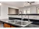 Close-up on the kitchen sink and faucet, featuring black countertops and modern fixtures at 8848 W Cordes Rd, Tolleson, AZ 85353