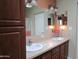 Bathroom with dual sinks, spacious vanity, and ample cabinet storage with views into the shower at 9302 E Broadway Rd # 157, Mesa, AZ 85208