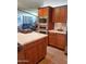 A kitchen with stainless steel appliances, brown cabinets, a kitchen island, and neutral tile flooring at 9302 E Broadway Rd # 157, Mesa, AZ 85208
