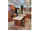 A kitchen with stainless steel appliances, brown cabinets, a kitchen island, and neutral tile flooring at 9302 E Broadway Rd # 157, Mesa, AZ 85208