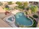 Overhead capture of a pool and spa with rock waterfall feature and outdoor dining area with pergola at 1015 E Constitution Dr, Gilbert, AZ 85296