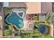 Aerial view of a private backyard featuring a pool, spa, seating area, trampoline and lush landscaping at 1015 E Constitution Dr, Gilbert, AZ 85296