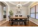 Inviting dining room with a wood table set, stylish chandelier, and a view of the landscaped backyard at 1015 E Constitution Dr, Gilbert, AZ 85296