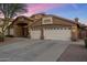 Exterior of a two-story home with a three-car garage and desert landscaping at 1015 E Constitution Dr, Gilbert, AZ 85296