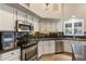 Well-equipped kitchen featuring stainless steel appliances, granite countertops, and sleek white cabinetry at 1015 E Constitution Dr, Gilbert, AZ 85296