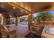 Built-in outdoor kitchen with bar seating, stone pillars, and ceiling fan at 1015 E Constitution Dr, Gilbert, AZ 85296