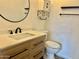 Bathroom with a sink, storage cabinet, commode, round mirror, and black hardware at 10201 N 97Th Ave # B, Peoria, AZ 85345