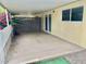 Concrete patio area with privacy lattice and brick accents, adjacent to a window and sliding glass door at 10201 N 97Th Ave # B, Peoria, AZ 85345