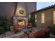 Backyard stone patio with fireplace, outdoor seating, and mature landscaping at 10287 E Diamond Rim Dr, Scottsdale, AZ 85255