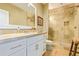 Elegant bathroom showcases a glass shower, sleek white vanity, and travertine tile, offering a spa-like experience at 10287 E Diamond Rim Dr, Scottsdale, AZ 85255