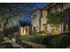 Inviting stone-clad home with manicured landscaping and warm exterior lighting at twilight at 10287 E Diamond Rim Dr, Scottsdale, AZ 85255