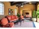 Comfortable outdoor living space with terracotta walls, ceiling fan, and stylish rust-colored furniture at 10287 E Diamond Rim Dr, Scottsdale, AZ 85255