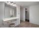 Bright bathroom vanity featuring a makeup station, ample lighting, and convenient storage at 10325 W Prairie Hills Cir, Sun City, AZ 85351