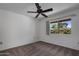 Well-lit bedroom with a window overlooking beautiful greenery and roses, and a cozy ceiling fan at 10325 W Prairie Hills Cir, Sun City, AZ 85351