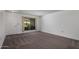 Empty bedroom featuring carpet, natural light from a window, and a white door at 10325 W Prairie Hills Cir, Sun City, AZ 85351