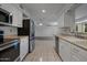 Bright kitchen featuring stainless steel appliances, white cabinetry, and tile flooring at 10325 W Prairie Hills Cir, Sun City, AZ 85351