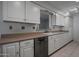 Bright kitchen features white cabinets, neutral countertops, and stainless steel dishwasher at 10325 W Prairie Hills Cir, Sun City, AZ 85351