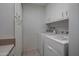 Convenient laundry room featuring washer, dryer, storage cabinets and neutral tile flooring at 10325 W Prairie Hills Cir, Sun City, AZ 85351