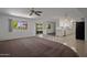 Open-concept living room with carpet flooring, ceiling fan, and natural light at 10325 W Prairie Hills Cir, Sun City, AZ 85351