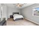 Cozy bedroom features carpet flooring, a ceiling fan, and a large window at 1036 S 75Th St, Mesa, AZ 85208