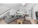 Open-concept layout features a modern gray sofa, light tile flooring, and stairs leading up to the second floor at 10420 N 10Th St # 2, Phoenix, AZ 85020