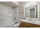 This bathroom features a shower-tub, a wood vanity with a light countertop, and a decorative mirror at 1050 S Stapley Dr # 62, Mesa, AZ 85204