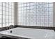 Modern tub with glass block window for natural light and privacy in the bathroom at 115 W El Freda Rd, Tempe, AZ 85284