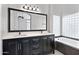Bathroom features a double sink vanity with dark wood cabinets and a large mirror at 115 W El Freda Rd, Tempe, AZ 85284